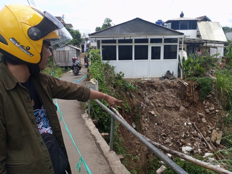 Warga pengendara menunjukan longsoran di Jalan GA Manulang Rancabali Atlas RT04/05, Desa Padalarang, Kecamatan Padalarang KBB (foto: Abdul Kholilulloh)