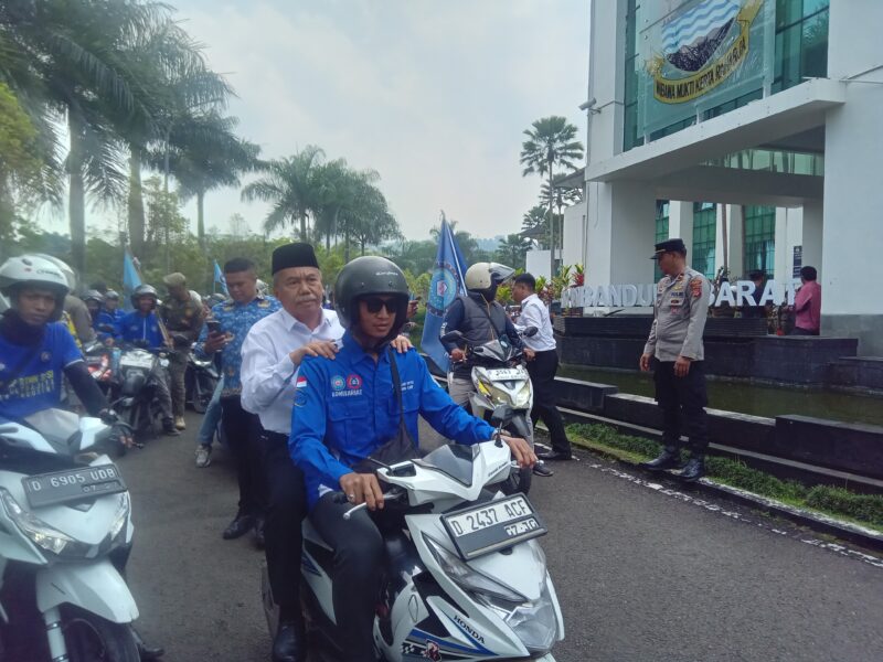 Momen Wakil Bupati Bandung Barat, Asep Ismail mengendarai sepeda motor menuju gedung DPRD KBB bersama ratusa masa aksi unras serikat pekerja (foto: Abdul Kholilulloh)
