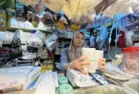 Seorang pedagang bernama Fery menunjukan jenis plastik yang mengalami kenaikan (foto: Abdul Kholilulloh)