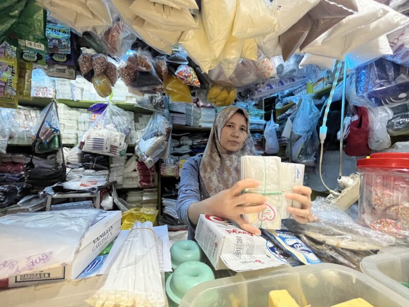 Seorang pedagang bernama Fery menunjukan jenis plastik yang mengalami kenaikan (foto: Abdul Kholilulloh)