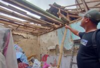 Warga menunjukan kondisi rumah Endang pasca ambruk bagian atap (foto: Abdul Kholilulloh)