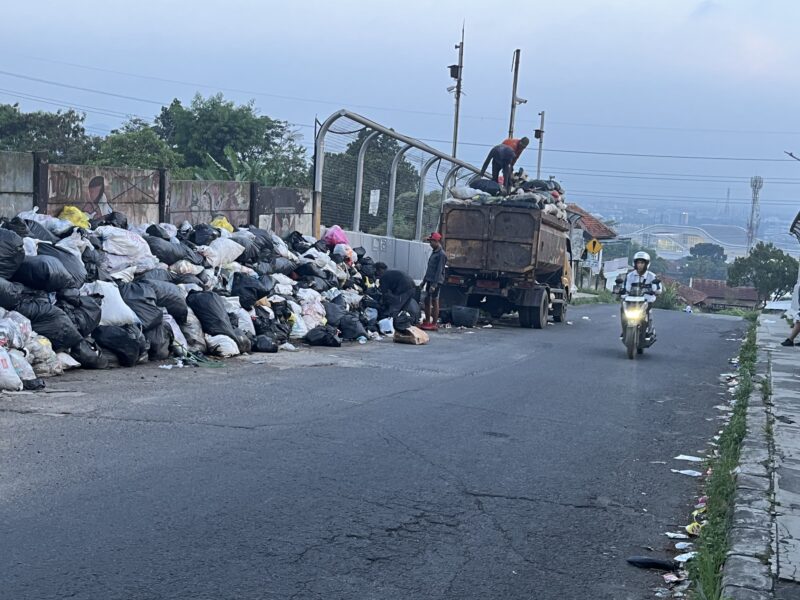Petugas UPT Kebersihan DLH KBB menarik tumpukan sampah pasca viral di Kampung Tanjakan Mama Utara, Desa Sukatani, Kecamatan Ngamprah, Kabupaten Bandung Barat (foto: Abdul Kholilulloh) 