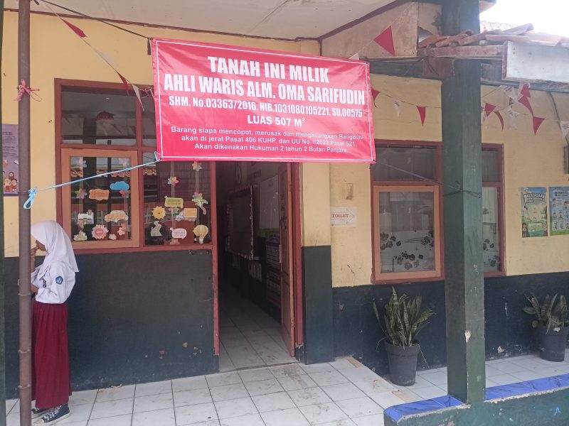 Ahli waris memasang spanduk pemberitahuan didepan ruang kelas siswa SDN 02 Kertamulya (foto: Abdul Kholilulloh)